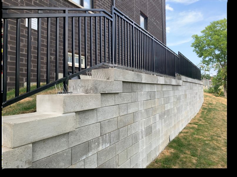 Black steel railing along a stepped retaining wall